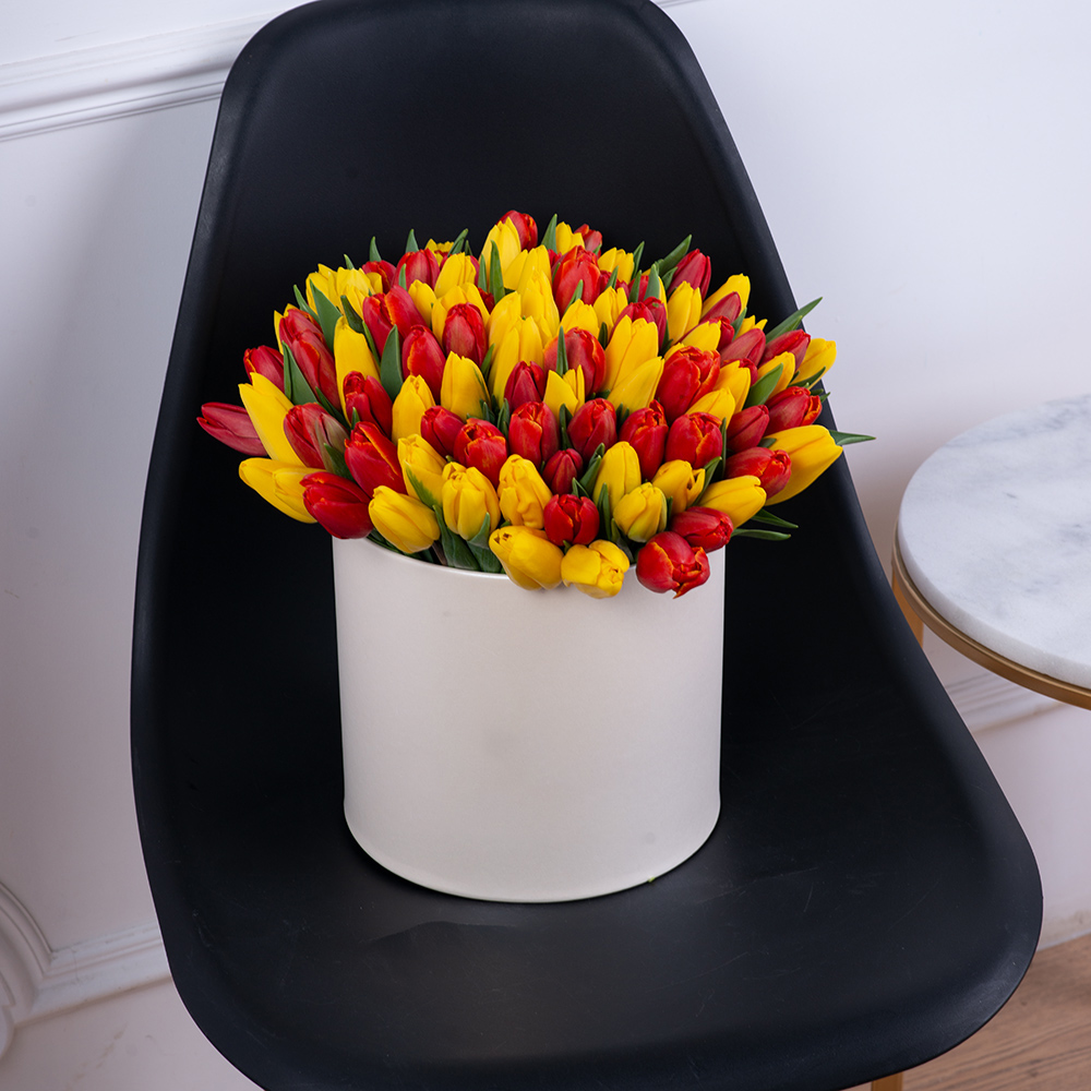 101 разноцветный тюльпан в шляпной кремовой коробке