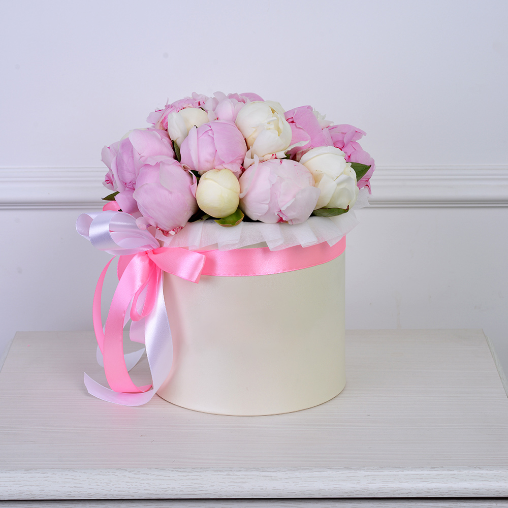Букет из 19 разноцветных пионов в кремовой шляпной коробке